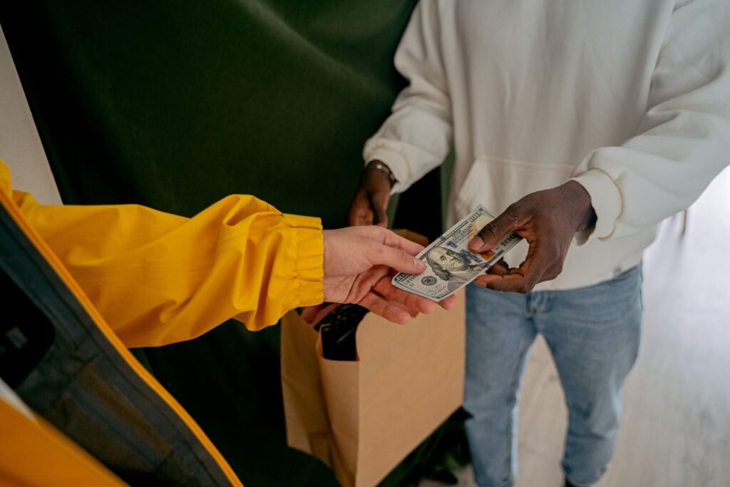 A close-up of a cash transaction between two adults, highlighting financial exchange.